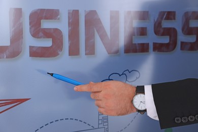 Photo of Business trainer with pen using interactive board, closeup