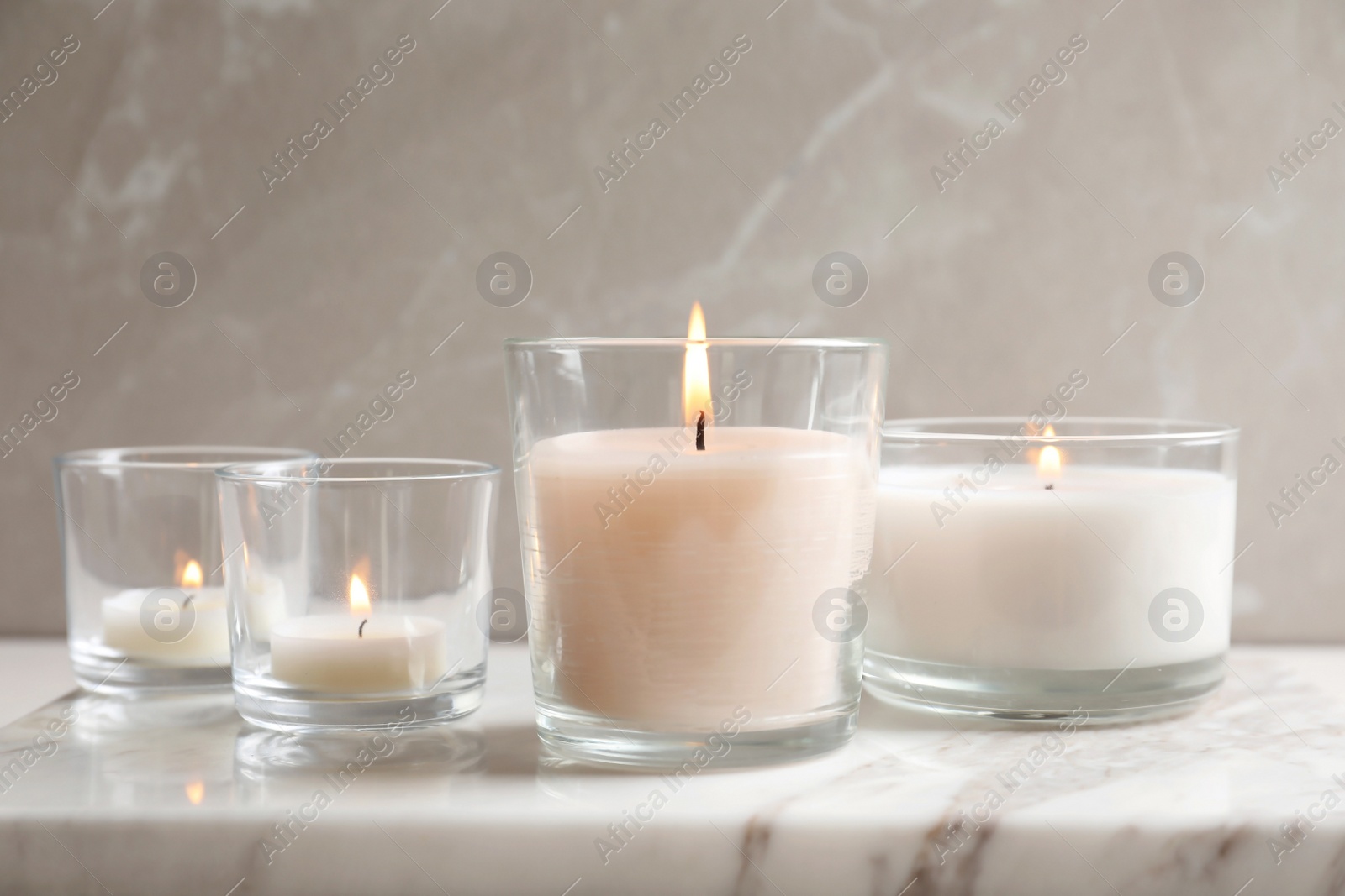 Photo of Burning candles in glasses on marble board