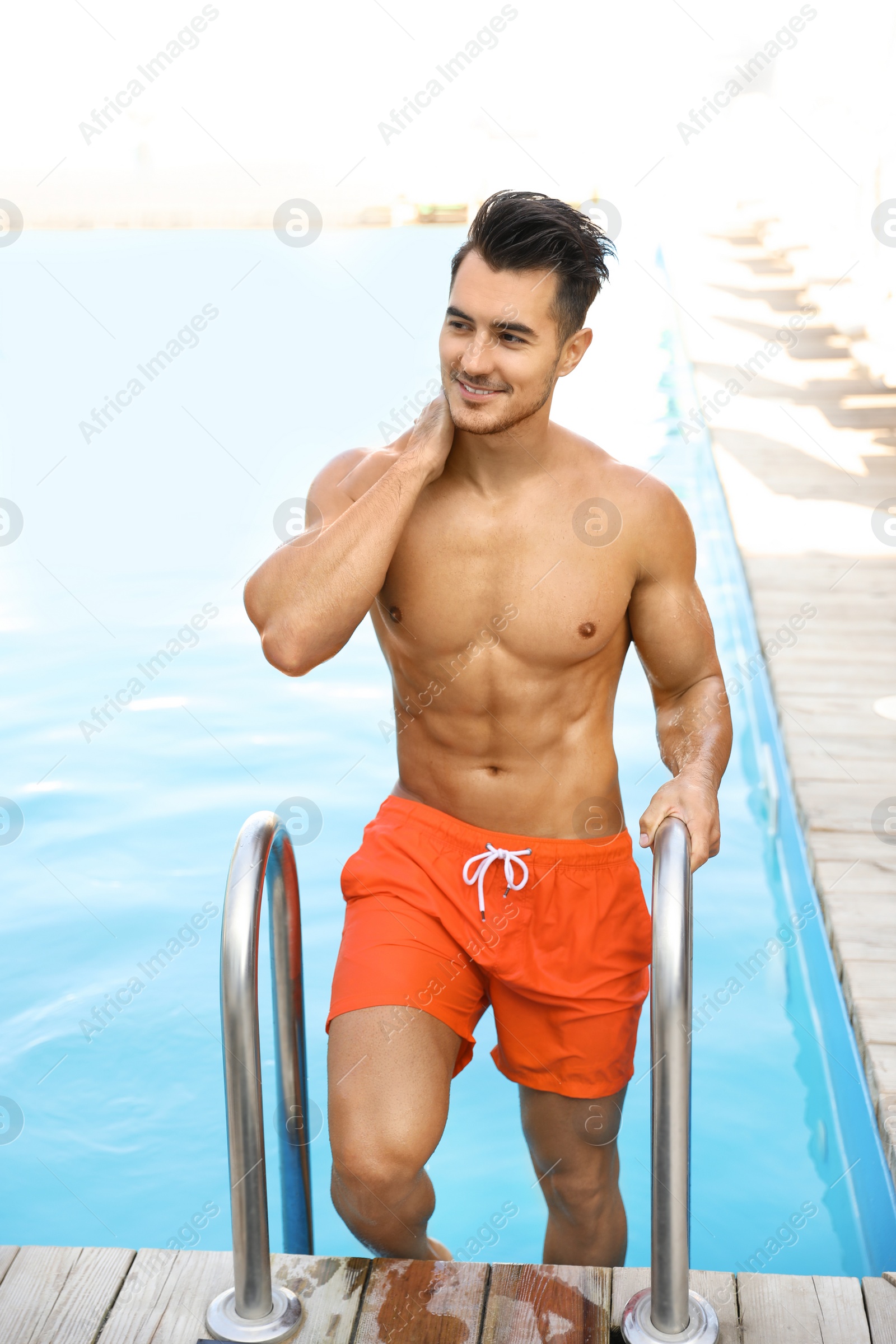 Photo of Young man getting out of outdoor pool