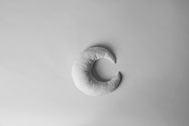 Photo of Soft pillow in shape of moon on light background