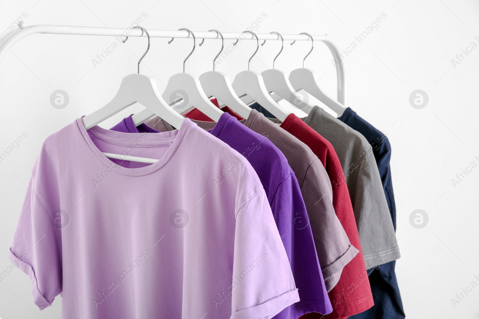 Photo of Men's clothes hanging on wardrobe rack against white background