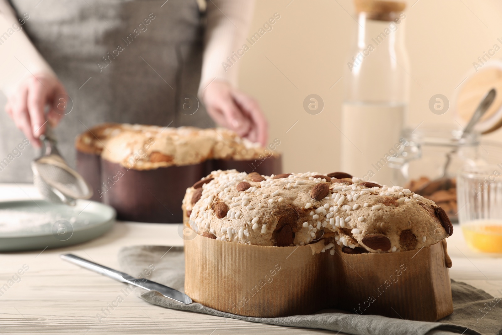 Photo of Delicious Italian Easter dove cake (traditional Colomba di Pasqua) on white wooden table, space for text