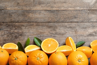 Flat lay composition with ripe oranges and space for text on wooden background