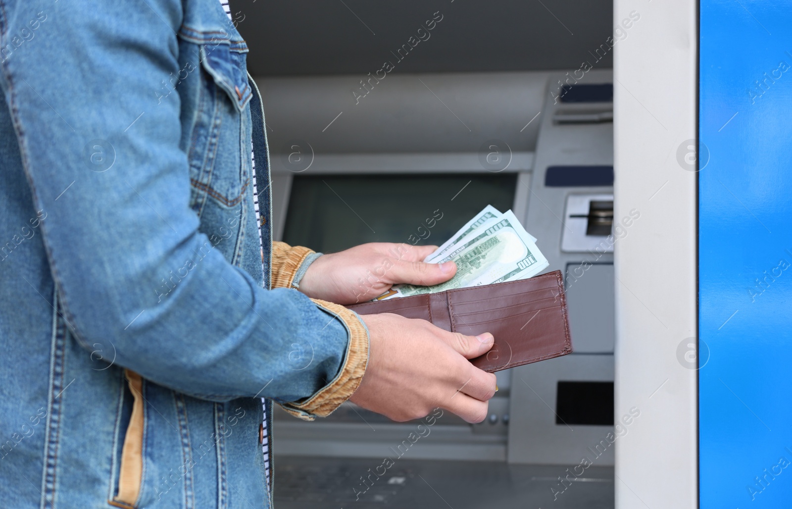 Photo of Man with money near cash machine outdoors, closeup