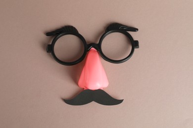Photo of Funny mask with fake mustache, nose and glasses on grey background, top view