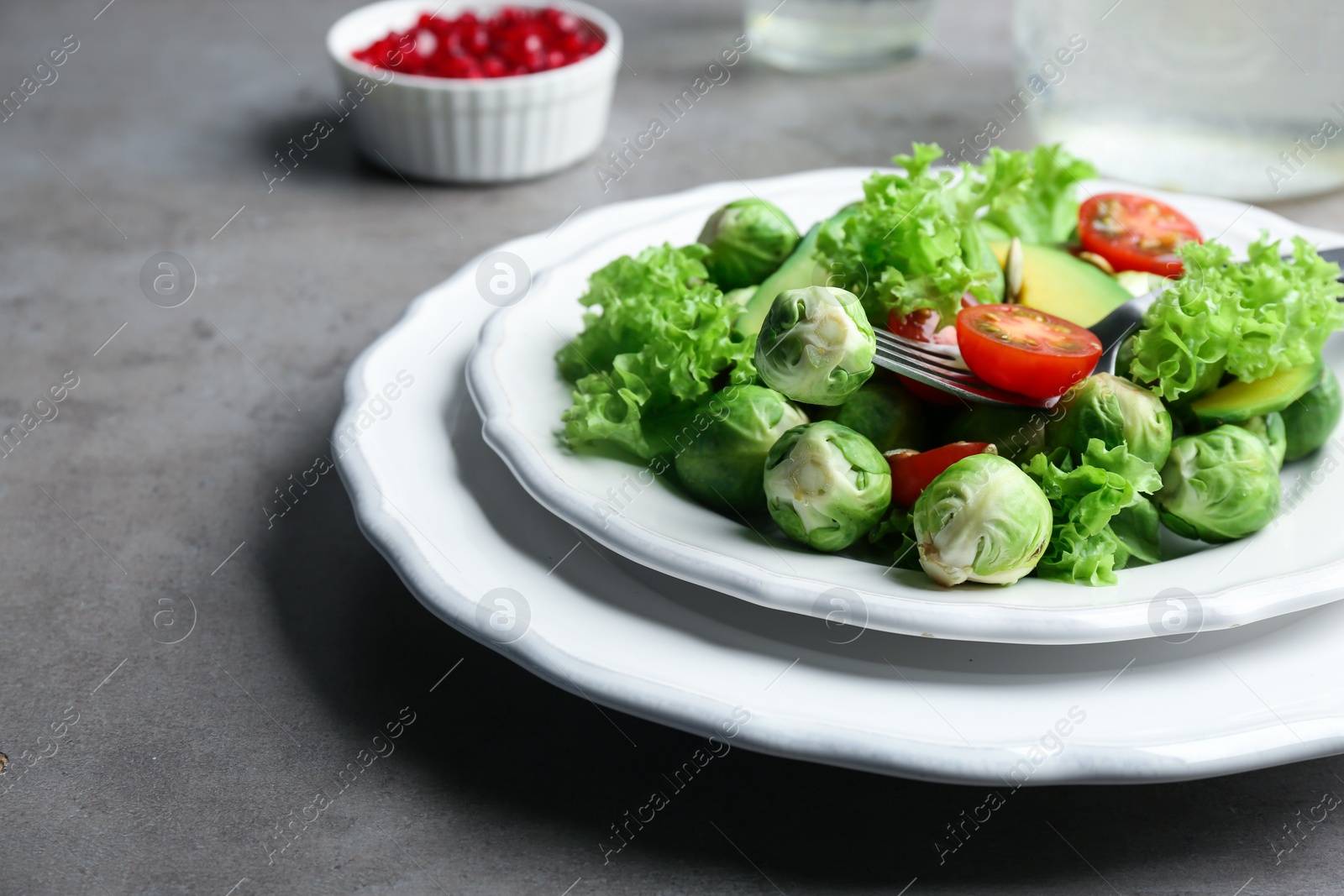 Photo of Tasty salad with Brussels sprouts served on grey table, closeup