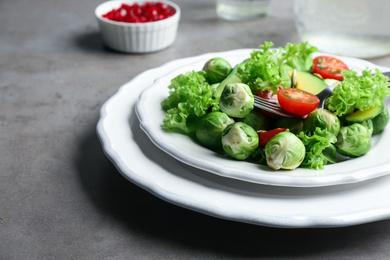 Tasty salad with Brussels sprouts served on grey table, closeup