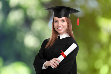 Image of Happy student with graduation hat and diploma on blurred background