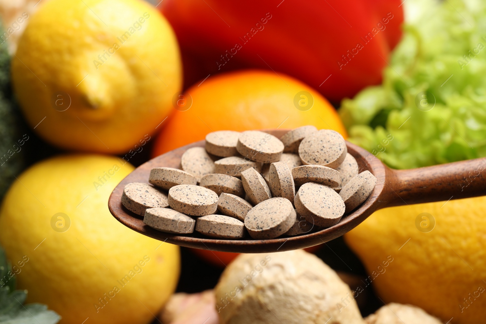 Photo of Dietary supplements. Spoon with pills over food products, closeup