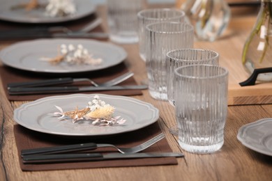 Photo of Elegant festive setting with floral decor on wooden table