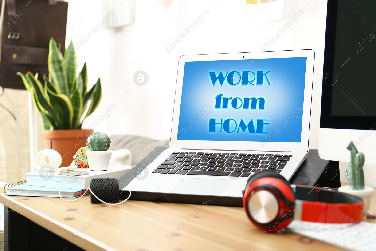 Image of Modern laptop with text WORK FROM HOME on table in office 