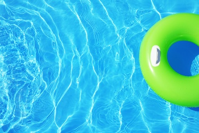 Photo of Inflatable ring floating in swimming pool on sunny day, top view with space for text