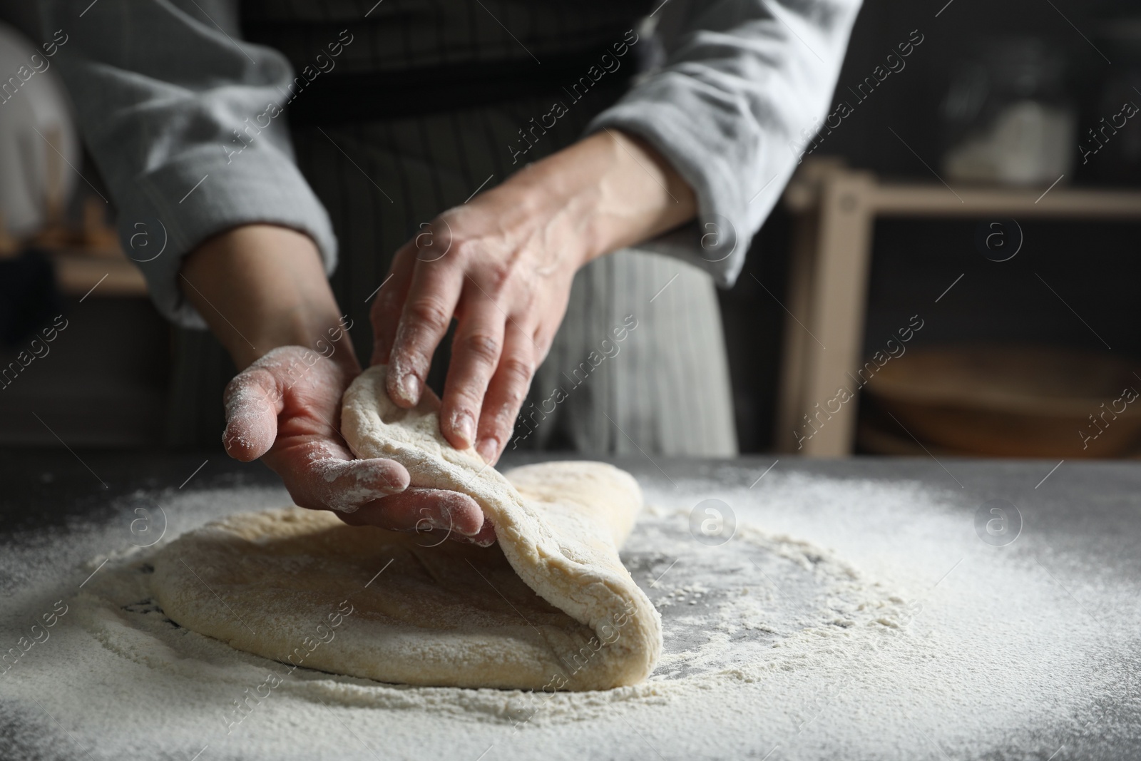 Photo of Woman making pizza dough at table, closeup