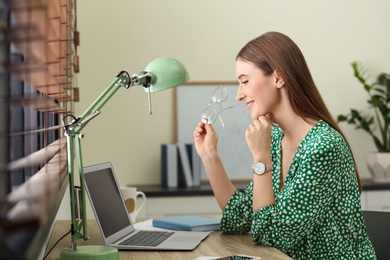 Image of Young woman working on laptop at home