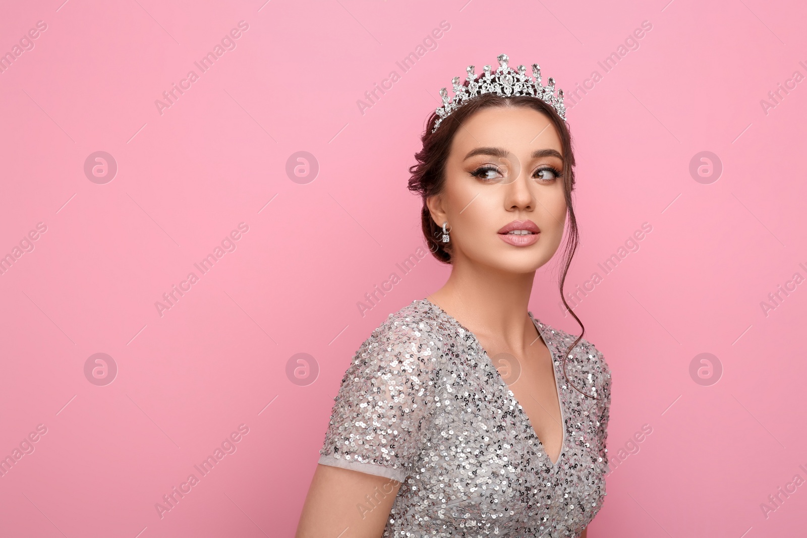 Photo of Beautiful young woman wearing luxurious tiara on pink background, space for text