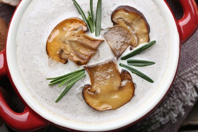 Fresh homemade mushroom soup in ceramic pot on table, top view