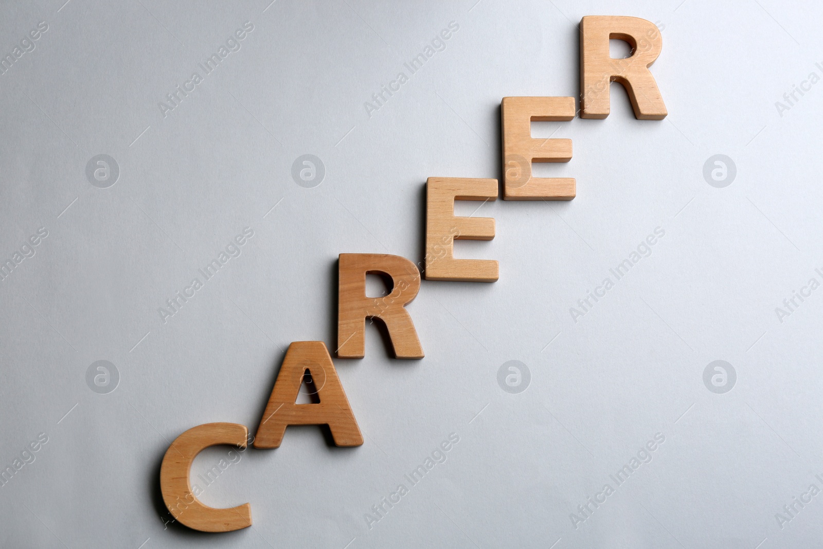 Photo of Word CAREER made of wooden letters on grey background, flat lay. Promotion concept
