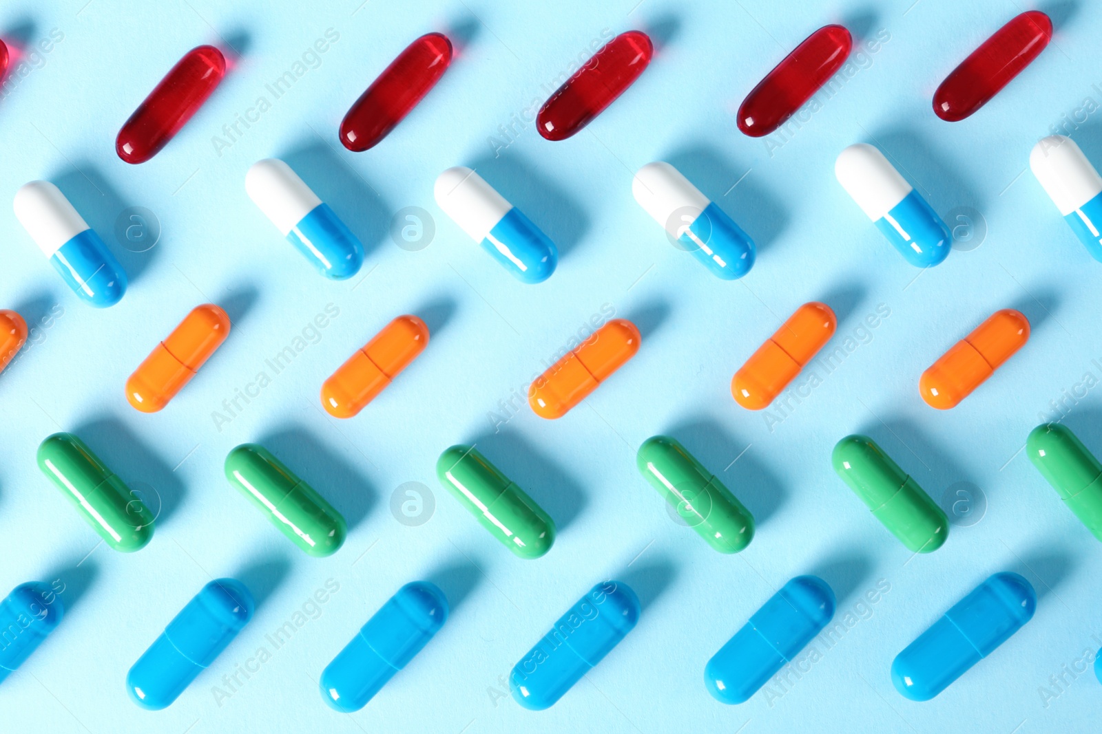 Photo of Different bright pills on color background, flat lay