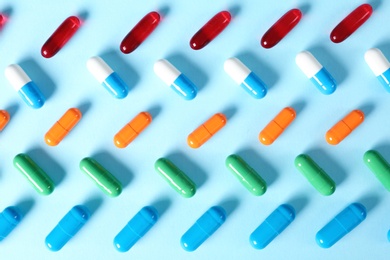 Different bright pills on color background, flat lay