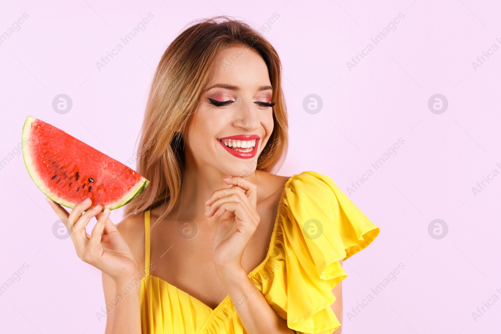 Photo of Pretty young woman with juicy watermelon on color background