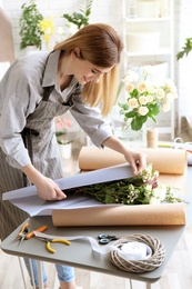 Photo of Female florist creating bouquet at workplace