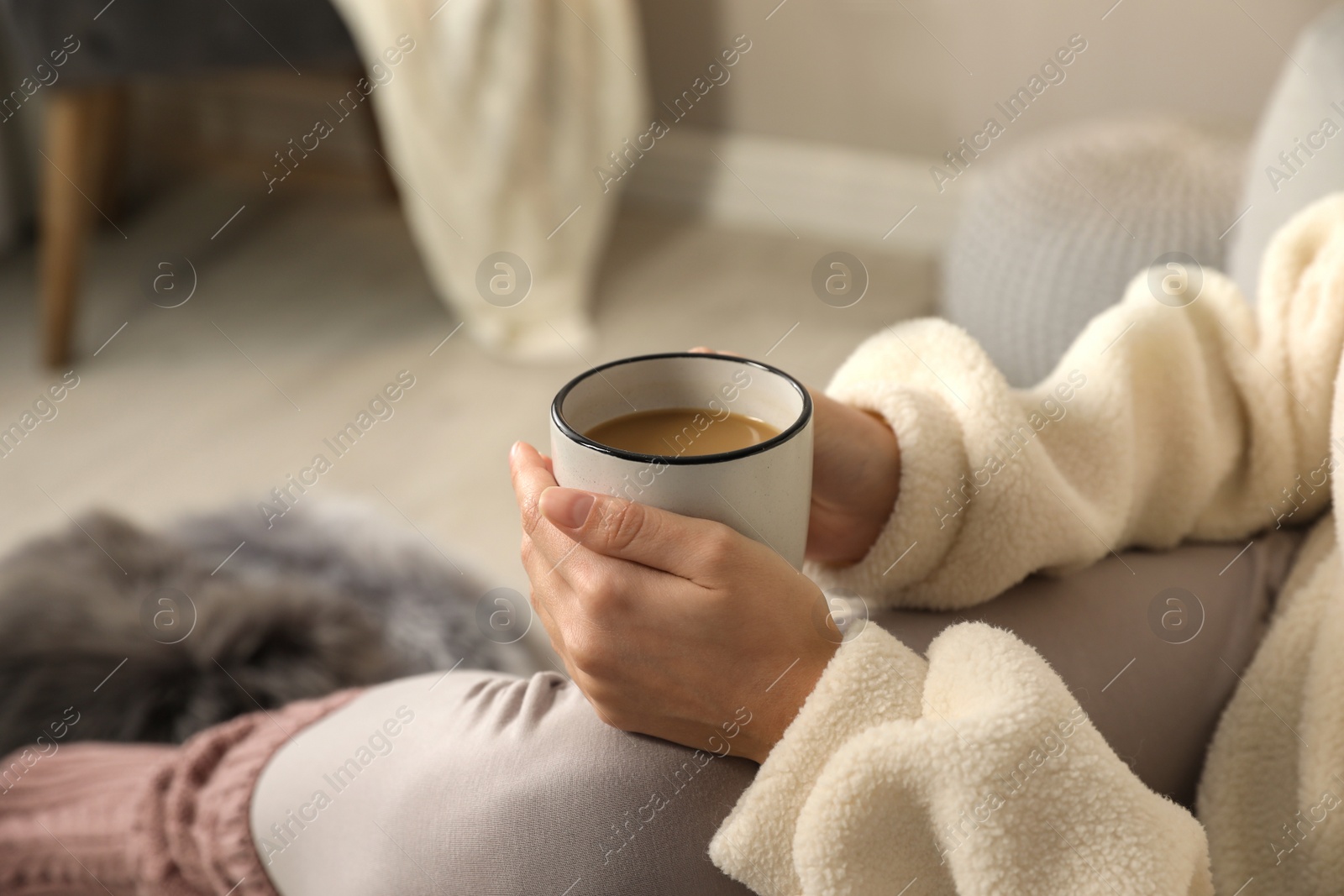 Photo of Woman with cup of hot drink resting at home, closeup