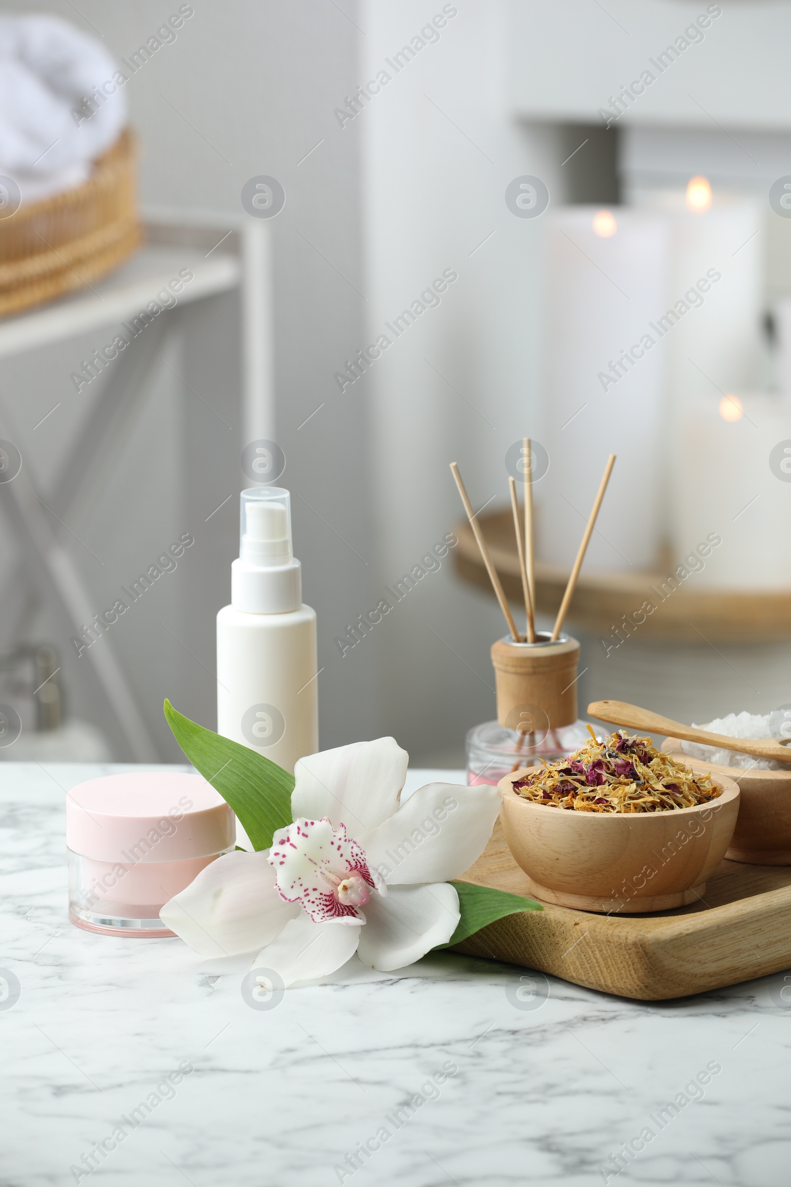 Photo of Beautiful composition with different spa products and orchid flower on white marble table indoors