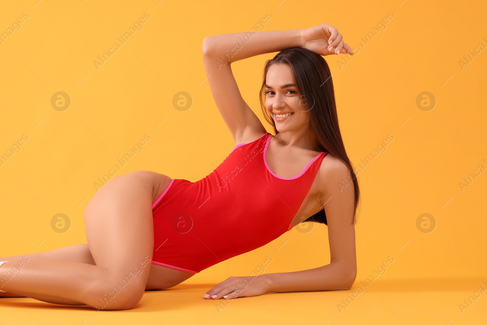 Photo of Young woman in stylish swimsuit on yellow background