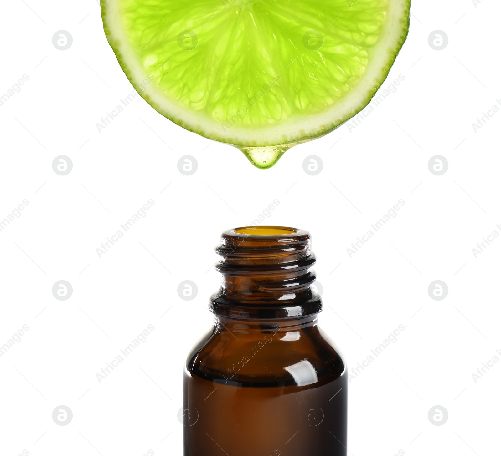 Photo of Essential oil dripping from lime slice into bottle isolated on white