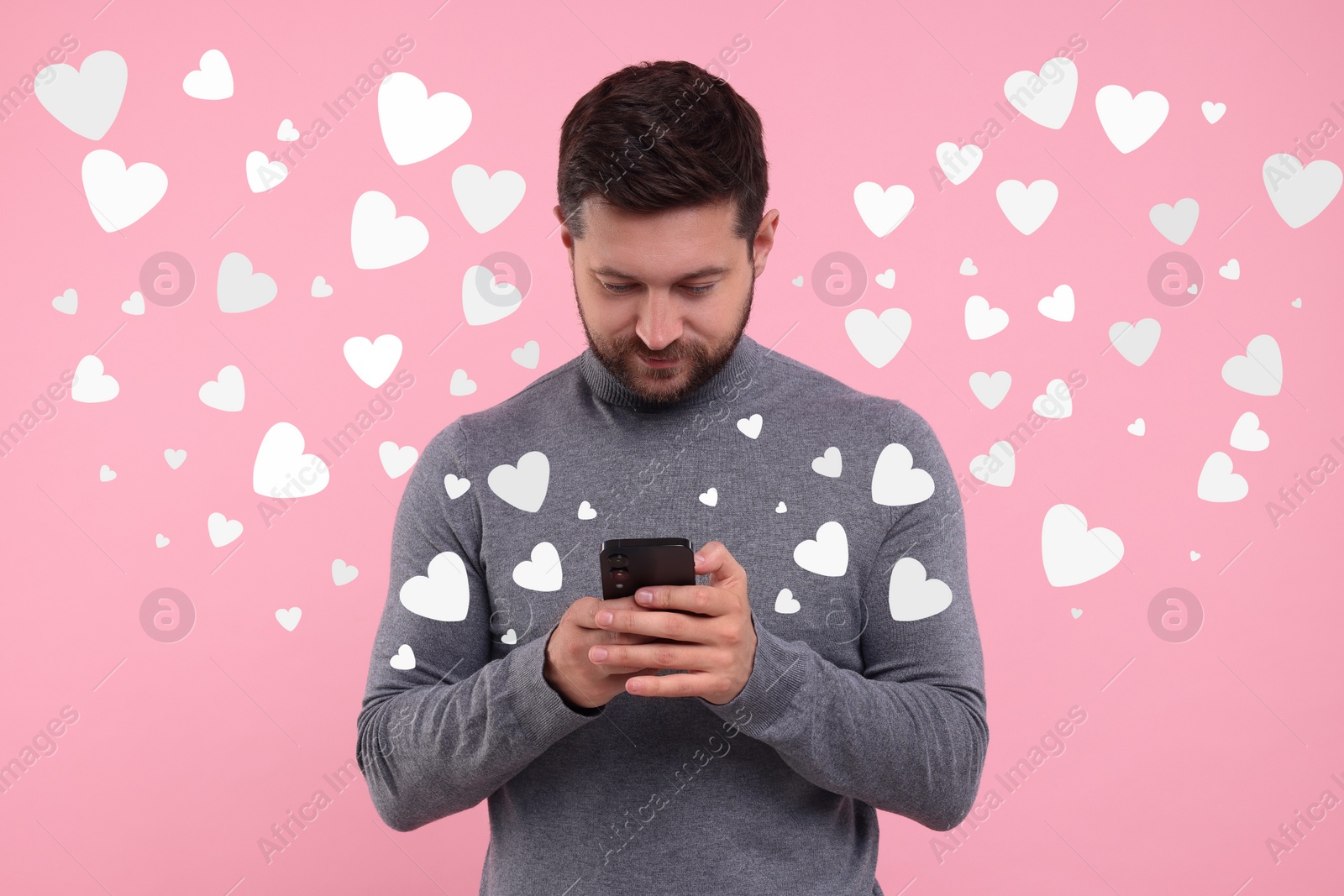 Image of Long distance love. Man chatting with sweetheart via smartphone on pink background. Hearts flying out of device and swirling around him