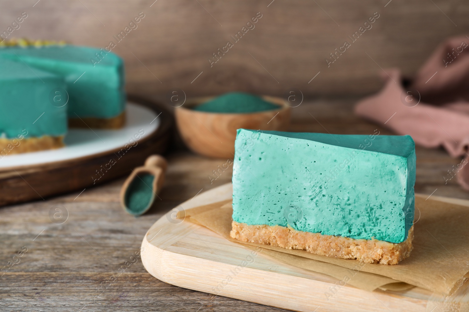 Photo of Piece of delicious homemade spirulina cheesecake on wooden table