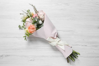 Photo of Bouquet of beautiful flowers on white wooden table, top view