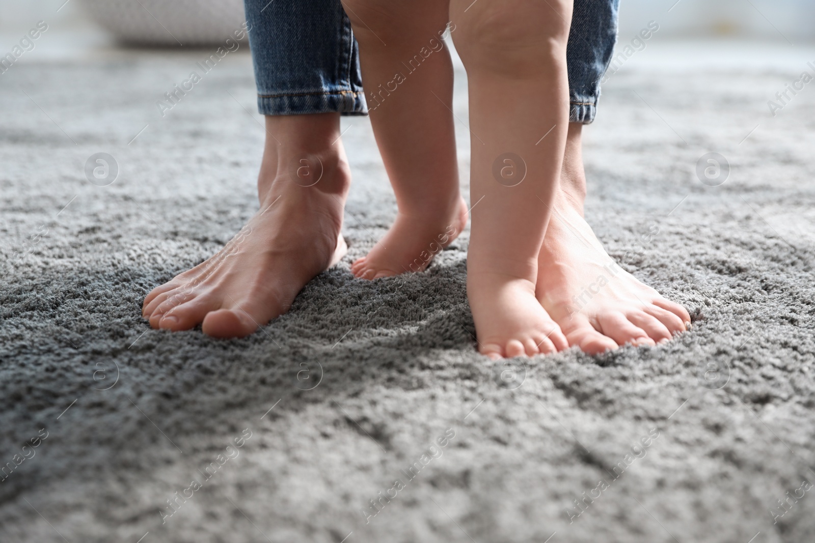 Photo of Baby doing first steps with mother's help, closeup