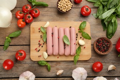 Photo of Flat lay composition with raw vegetarian sausages on wooden table