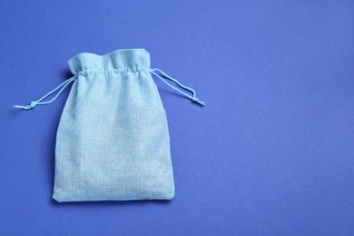 Photo of Burlap bag on blue background, top view. Space for text