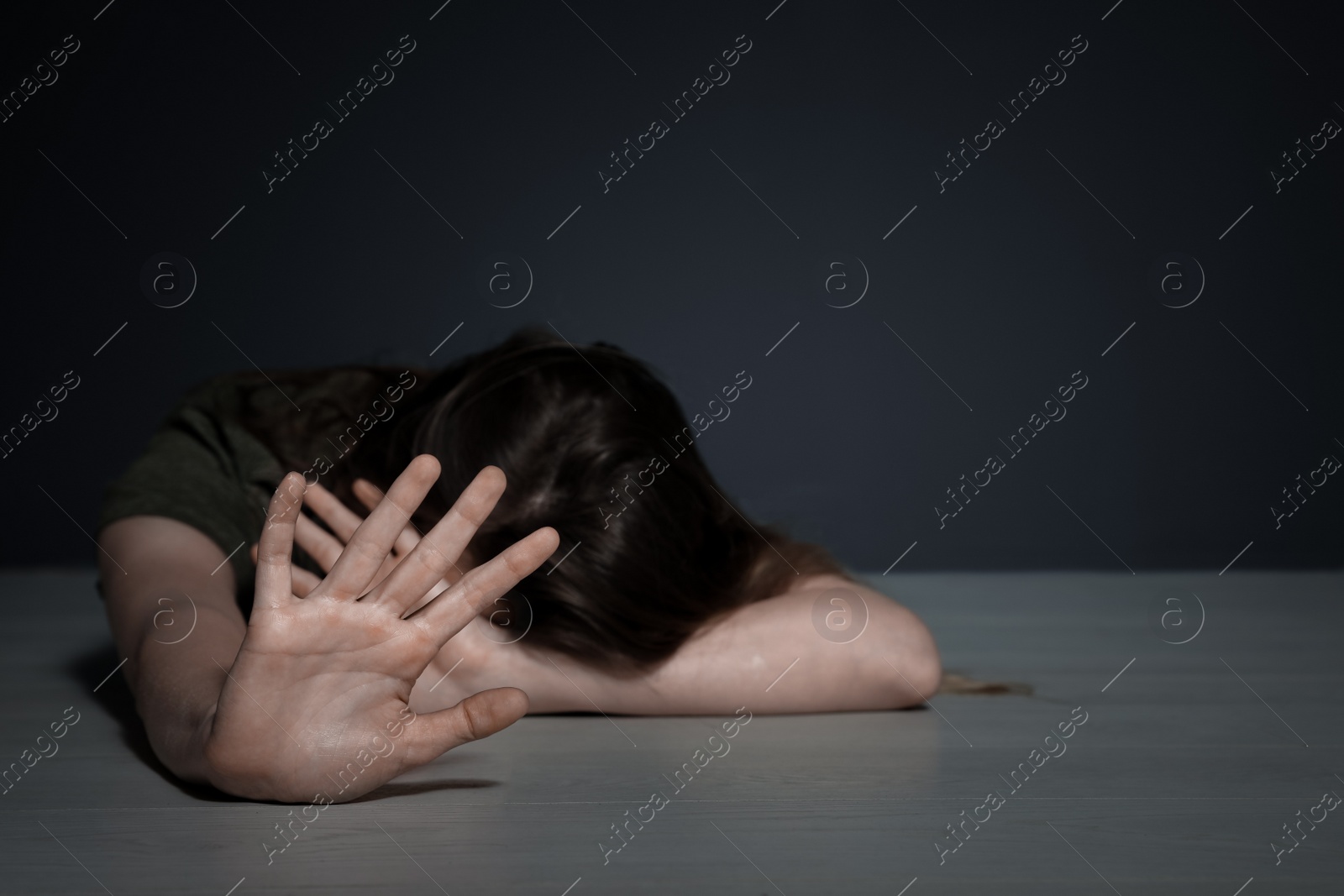 Photo of Young woman making stop gesture while lying on floor indoors. Space for text