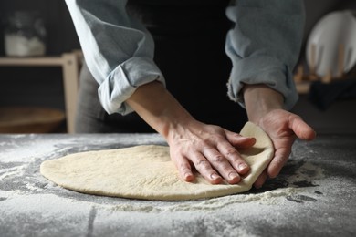 Photo of Woman making pizza dough at table, closeup