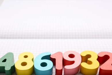 Colorful numbers on notebook with grid pages. Space for text