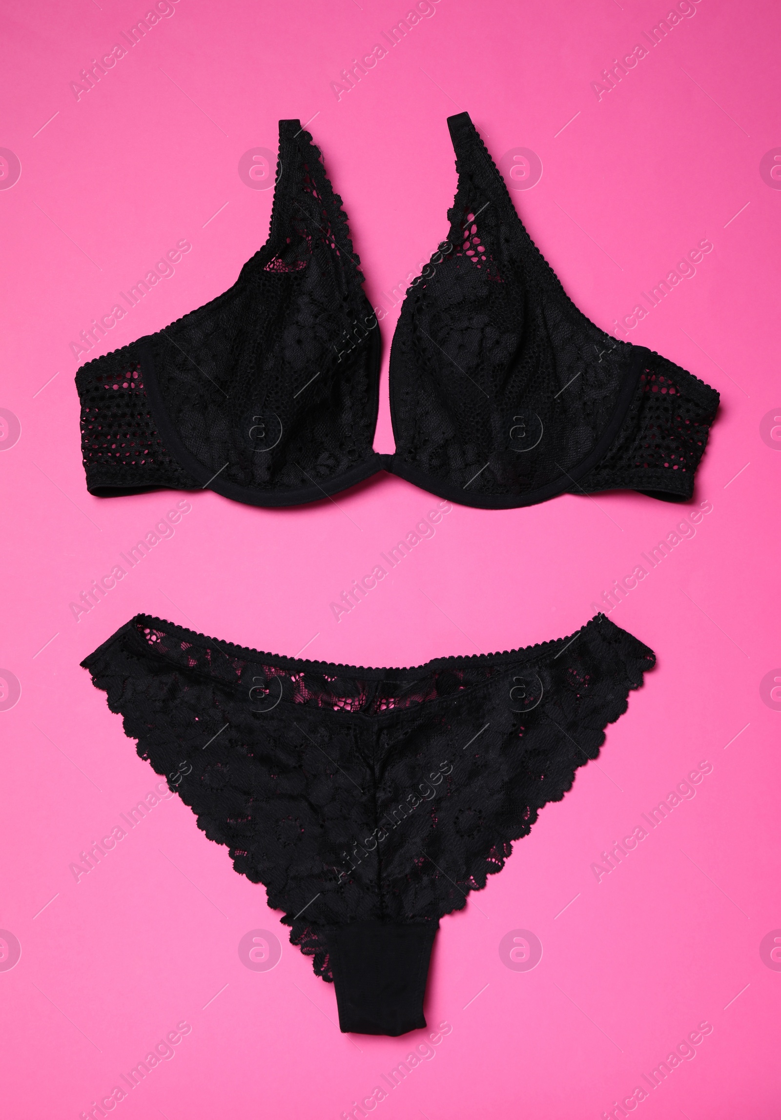 Photo of Set of black lace lingerie on pink background, flat lay