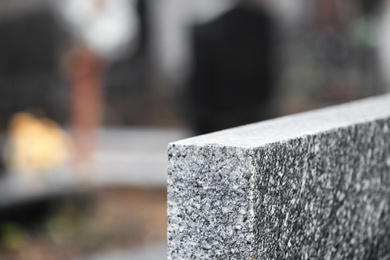 Photo of Light grey granite tombstone outdoors, closeup with space for text. Funeral ceremony