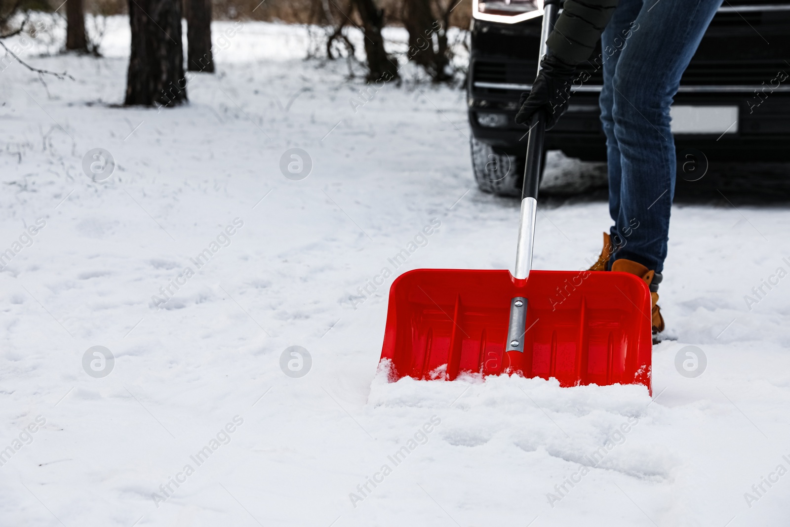 Photo of Man removing snow with shovel near car outdoors on winter day, closeup