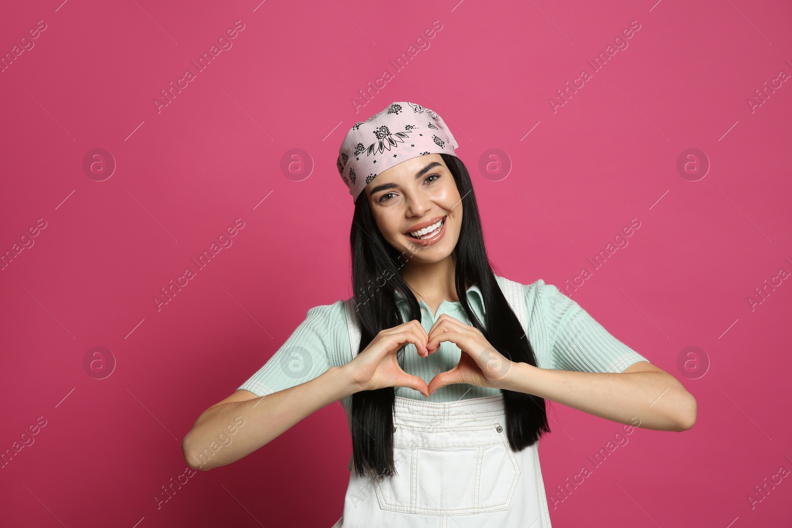 Photo of Young woman wearing stylish bandana on pink background