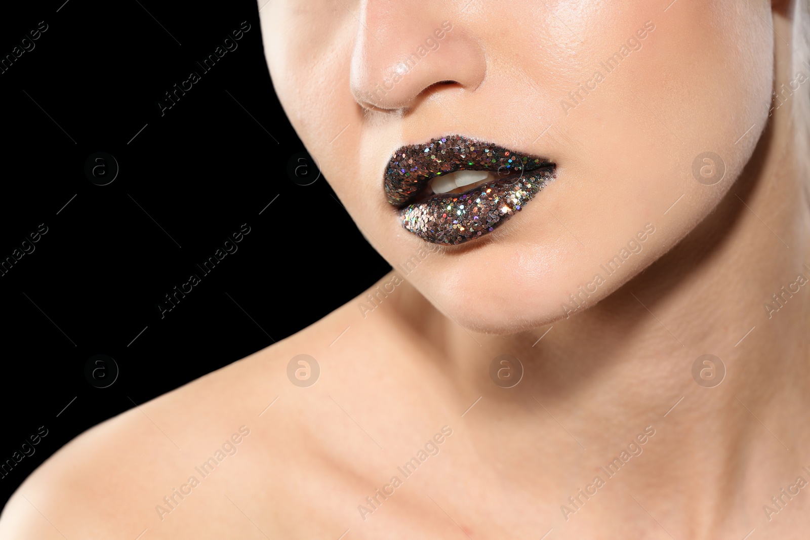 Photo of Beautiful young model with creative lips makeup on black background