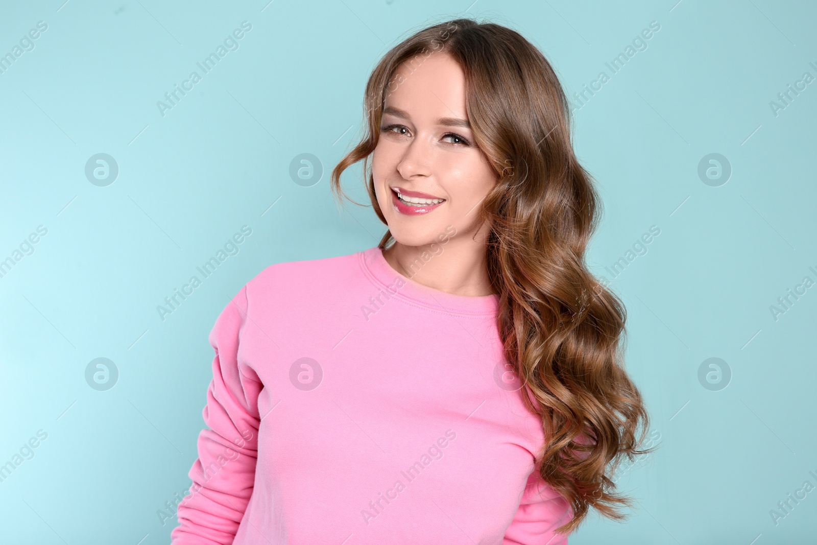 Photo of Portrait of young woman with long beautiful hair on color background