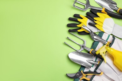 Photo of Flat lay composition with gardening tools on green background, space for text