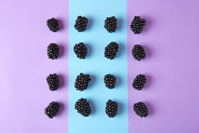 Photo of Tasty ripe blackberries on color background, flat lay