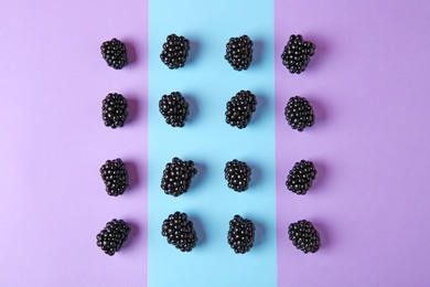 Tasty ripe blackberries on color background, flat lay