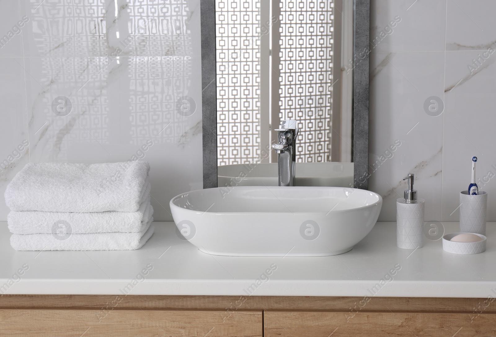 Photo of Modern mirror and vessel sink in stylish bathroom