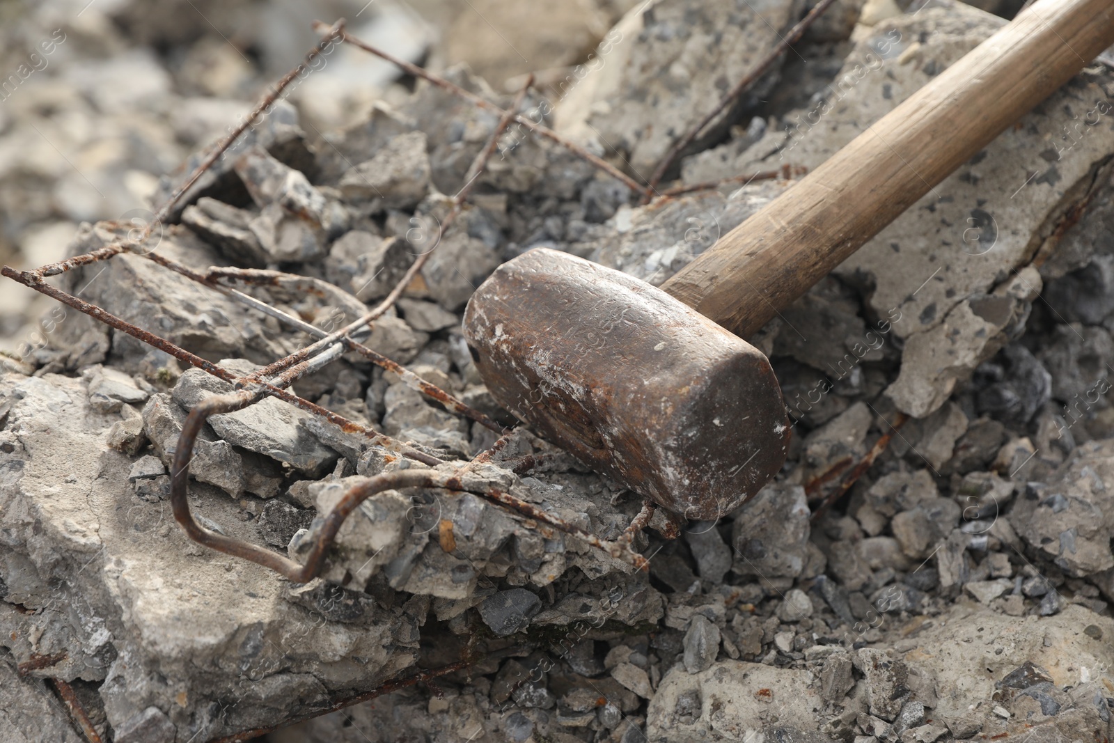 Photo of Sledgehammer on pile of broken stones outdoors, closeup