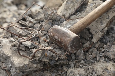 Sledgehammer on pile of broken stones outdoors, closeup